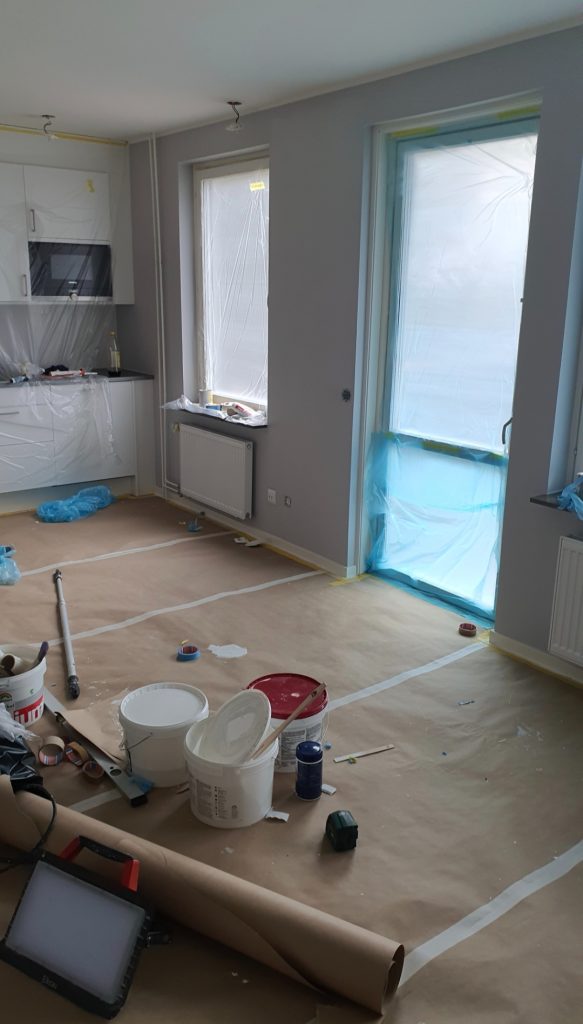 Invändig målning i Stockholm - Noggrann kantskärning där vägg möter tak och foder.