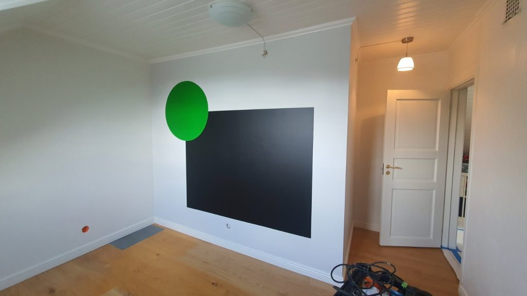 Invändig målning i Stockholm - Lekfull accentvägg: svart tavelvägg med grön cirkel i ett barnrum.